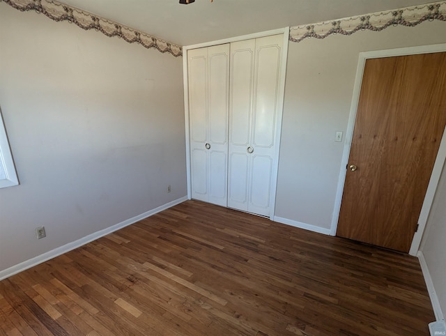 unfurnished bedroom featuring dark hardwood / wood-style flooring and a closet