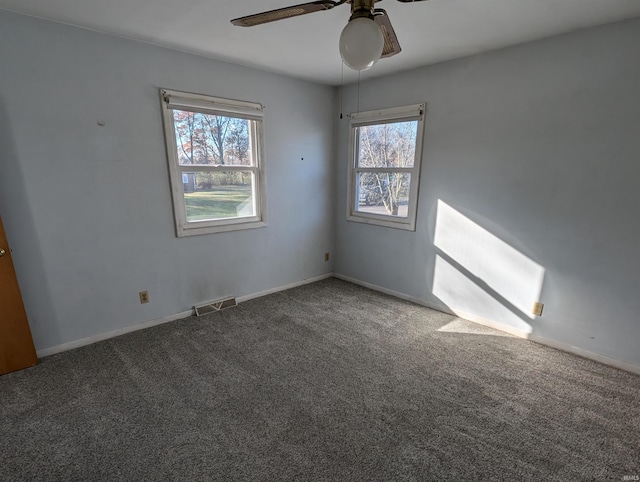 carpeted spare room with ceiling fan and a healthy amount of sunlight