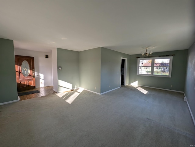 unfurnished room featuring hardwood / wood-style flooring and an inviting chandelier