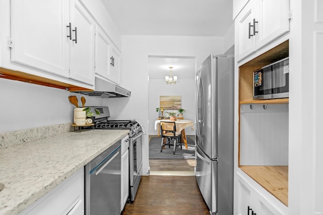 kitchen with light stone countertops, white cabinetry, dark wood-type flooring, an inviting chandelier, and appliances with stainless steel finishes