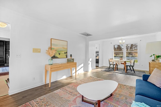 living room with dark wood-type flooring and an inviting chandelier