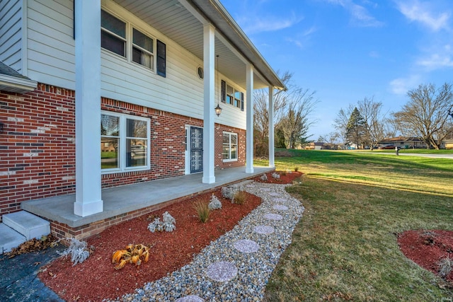 exterior space featuring covered porch and a yard