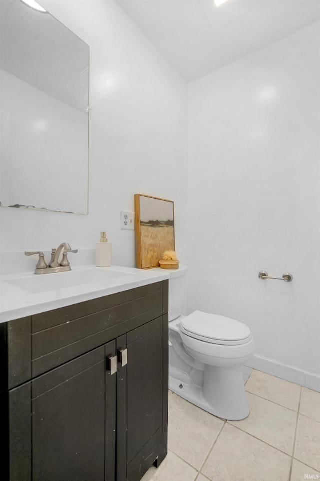 bathroom with toilet, vanity, and tile patterned floors