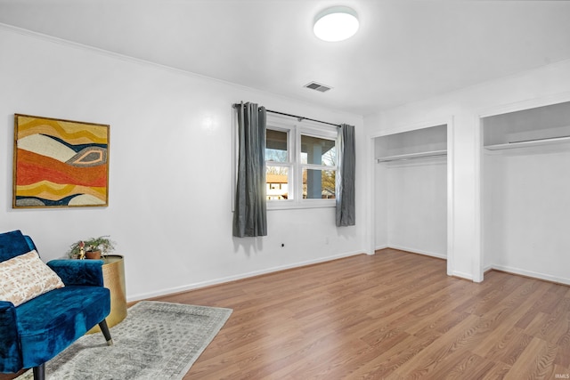 sitting room featuring light hardwood / wood-style flooring and ornamental molding