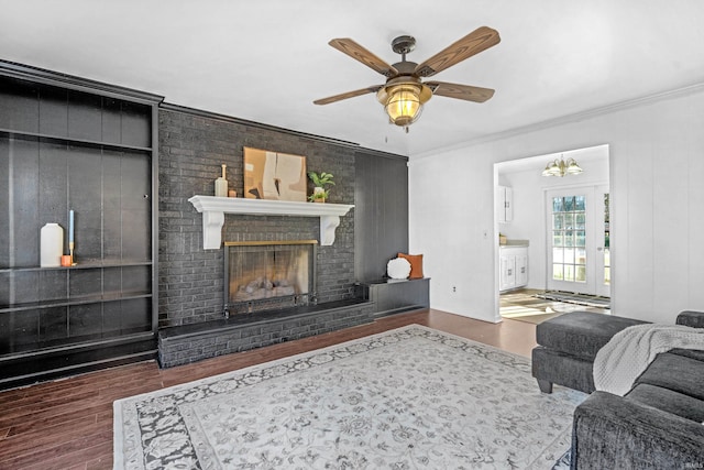 living room with a fireplace, dark hardwood / wood-style floors, ceiling fan, and crown molding