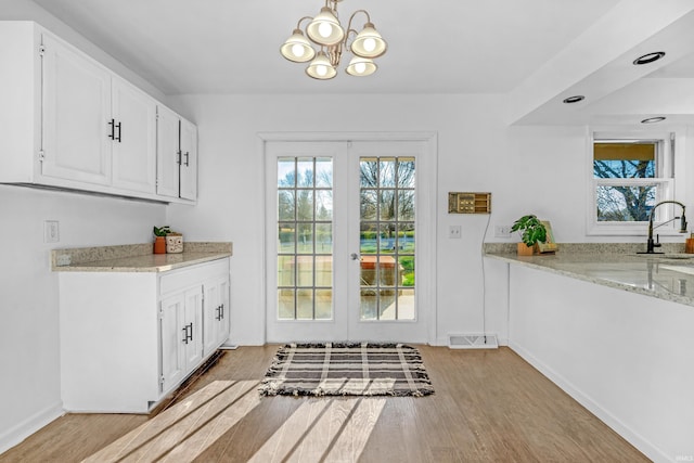 entryway with a chandelier, light hardwood / wood-style flooring, a healthy amount of sunlight, and sink