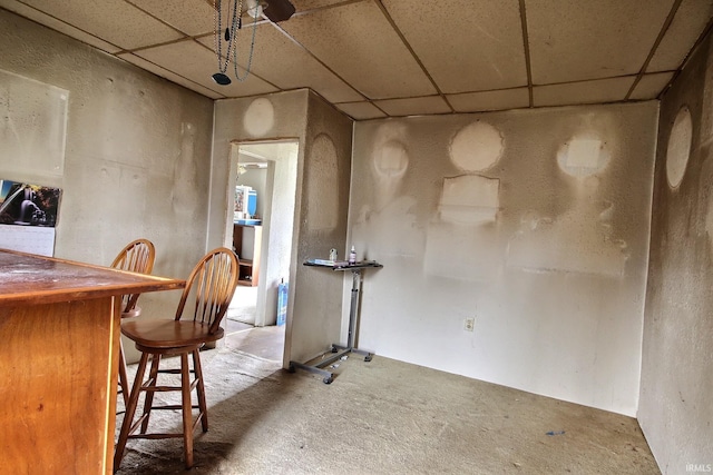 carpeted dining room with a drop ceiling