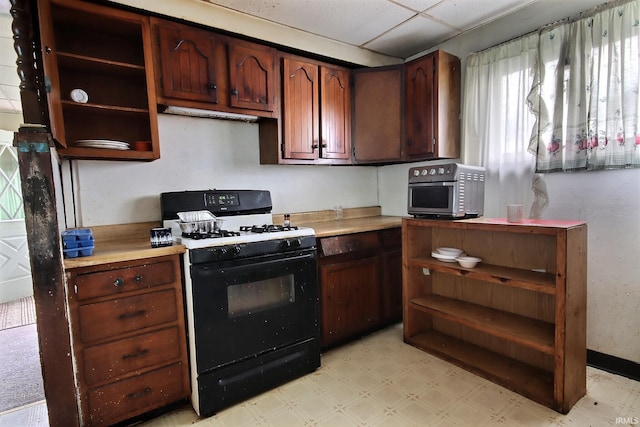 kitchen with a paneled ceiling and black range with gas cooktop