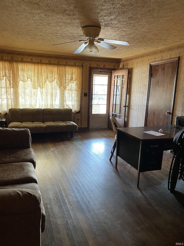 living room featuring a ceiling fan, wood-type flooring, crown molding, and a textured ceiling