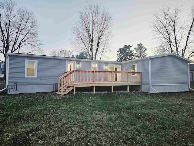 rear view of house with a deck, central AC unit, and a lawn