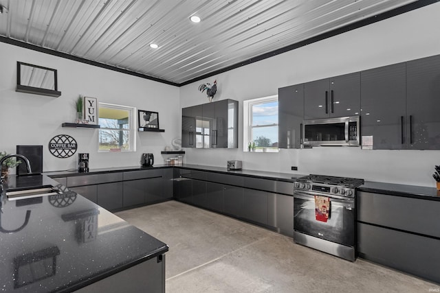 kitchen featuring stainless steel appliances, gray cabinets, dark stone countertops, and sink