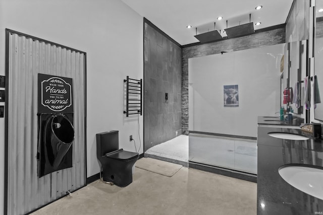 bathroom with concrete flooring, vanity, a shower, tile walls, and toilet