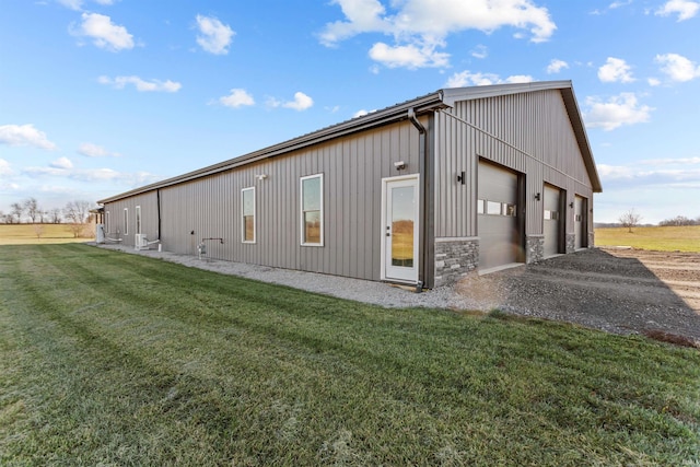 view of property exterior featuring a lawn, an outbuilding, and a garage