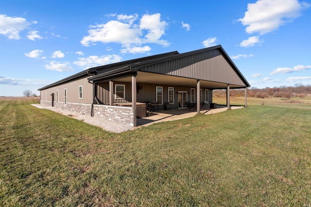 back of house with a patio area and a lawn