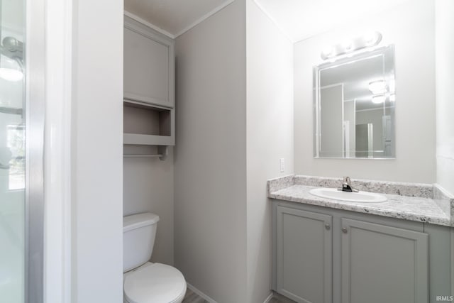 bathroom featuring vanity, toilet, and crown molding