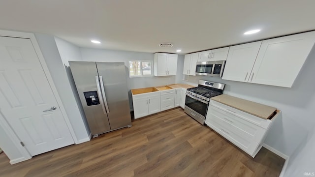 kitchen featuring dark wood-type flooring, white cabinets, and stainless steel appliances