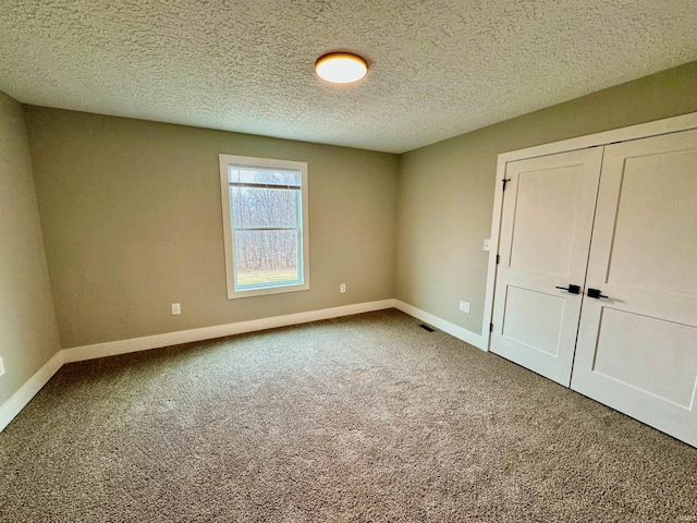 unfurnished bedroom featuring carpet and a textured ceiling