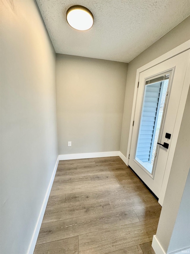 entryway featuring light wood-type flooring and a textured ceiling