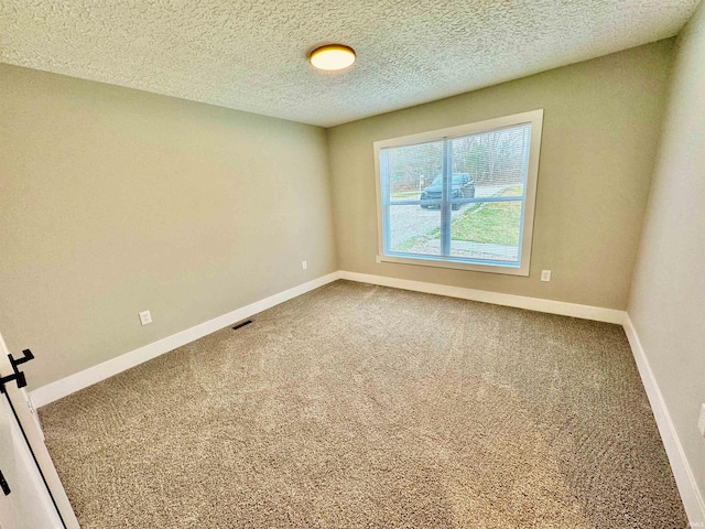 carpeted spare room featuring a textured ceiling