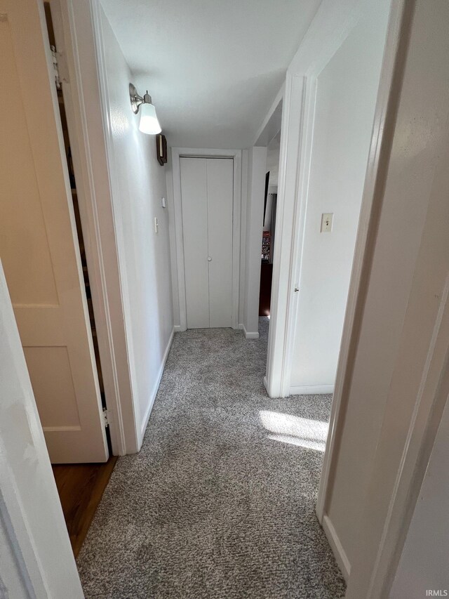 hallway with dark colored carpet