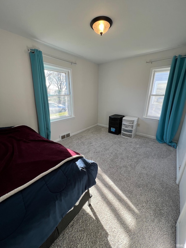 carpeted bedroom featuring multiple windows