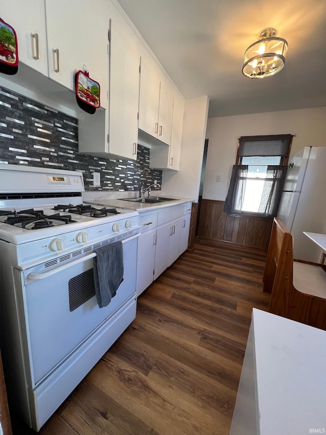 kitchen featuring white appliances, sink, tasteful backsplash, dark hardwood / wood-style flooring, and white cabinetry