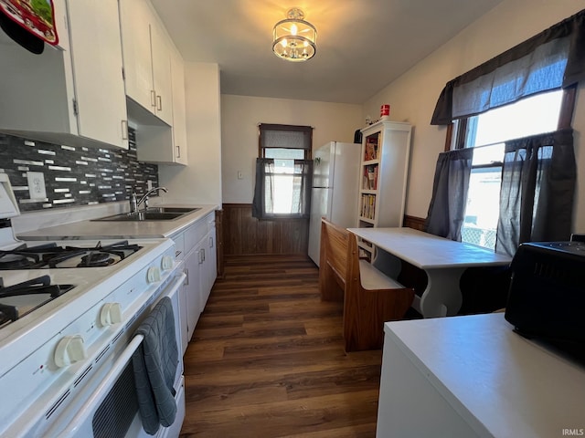 kitchen with sink, dark hardwood / wood-style flooring, white appliances, decorative backsplash, and white cabinets