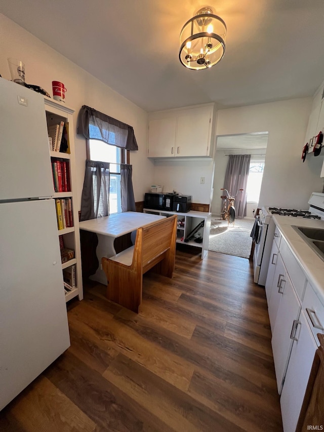 kitchen with white cabinetry, dark hardwood / wood-style flooring, and white appliances