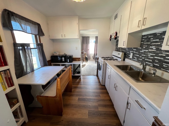 kitchen featuring white cabinetry, sink, tasteful backsplash, dark hardwood / wood-style floors, and white gas range oven