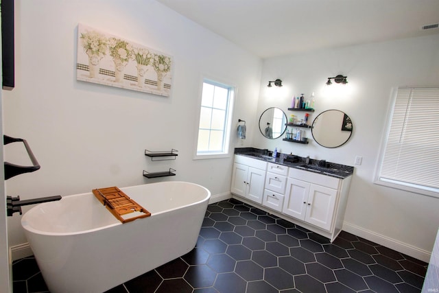 bathroom with tile patterned flooring, a bathtub, and vanity