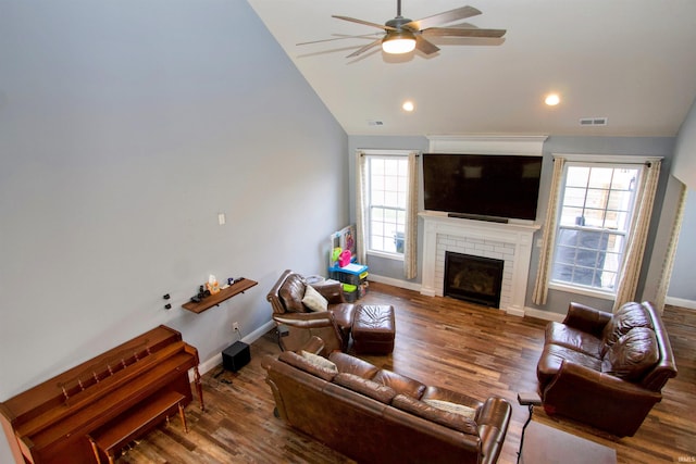 living room with a fireplace, wood-type flooring, ceiling fan, and lofted ceiling