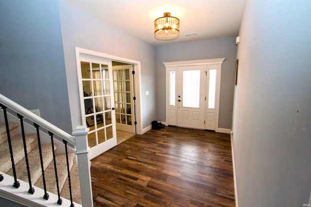 foyer with a notable chandelier and dark wood-type flooring