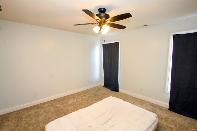 bedroom with ceiling fan and light carpet