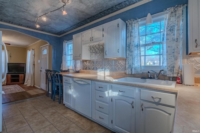 kitchen with ornamental molding, white appliances, sink, light tile patterned floors, and white cabinetry