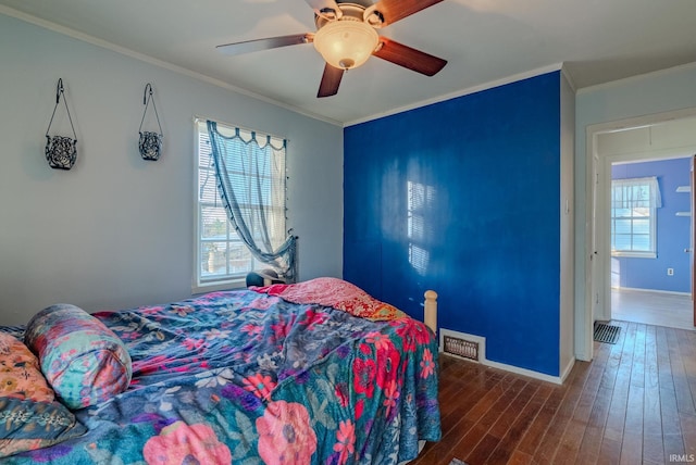 bedroom with ceiling fan, ornamental molding, and dark wood-type flooring