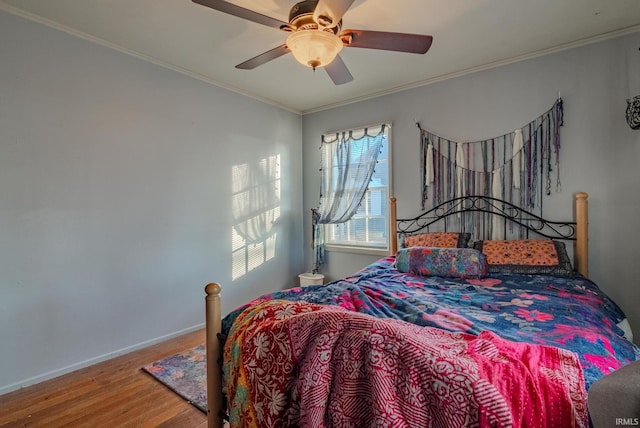 bedroom with hardwood / wood-style floors, ceiling fan, and ornamental molding