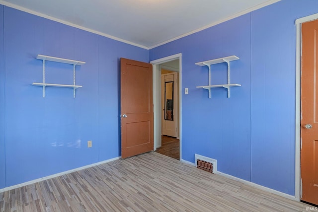 unfurnished room featuring light wood-type flooring and ornamental molding