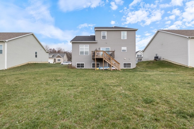 rear view of house featuring a yard and a wooden deck