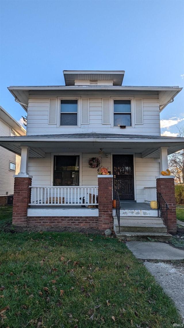 view of front of property with covered porch and a front lawn