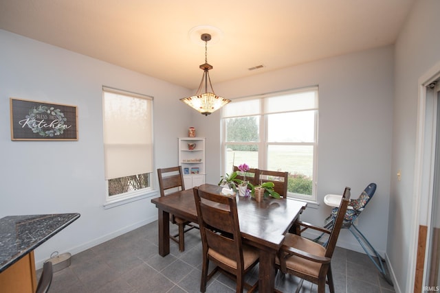 dining space with dark tile patterned floors