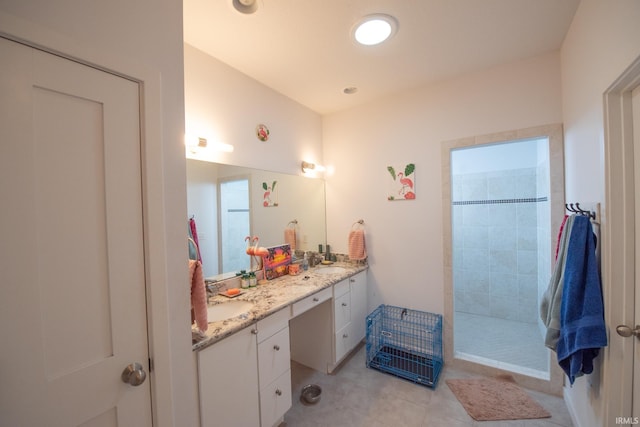 bathroom featuring vanity, tile patterned floors, and a tile shower