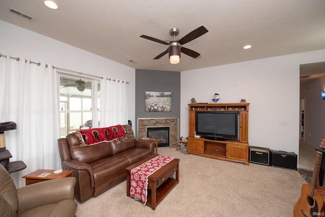 carpeted living room with ceiling fan and a textured ceiling