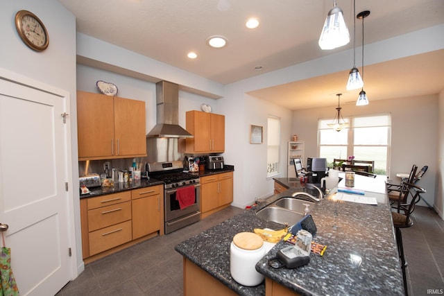 kitchen with sink, decorative light fixtures, gas stove, and wall chimney exhaust hood