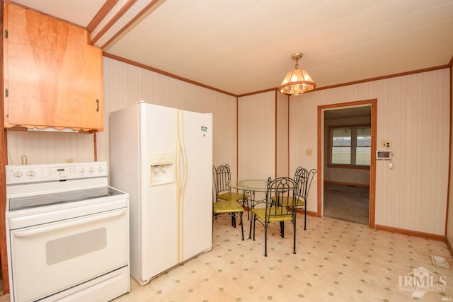 kitchen with hanging light fixtures, an inviting chandelier, white appliances, light carpet, and ornamental molding