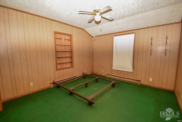 recreation room featuring dark colored carpet, built in features, ceiling fan, and wood walls