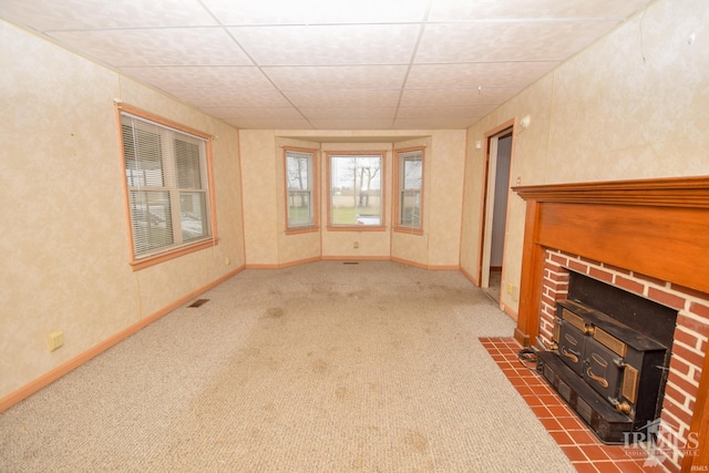 unfurnished living room featuring carpet flooring and a paneled ceiling