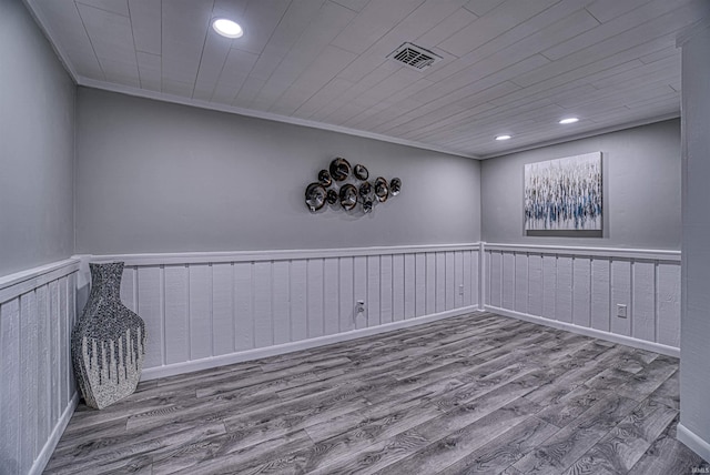 spare room with wooden walls, hardwood / wood-style floors, and ornamental molding