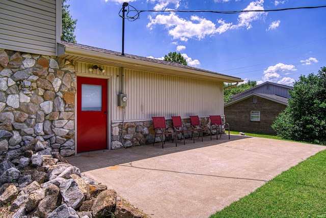 view of exterior entry featuring a patio area