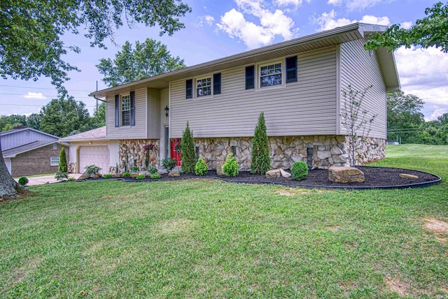 raised ranch featuring a front yard and a garage