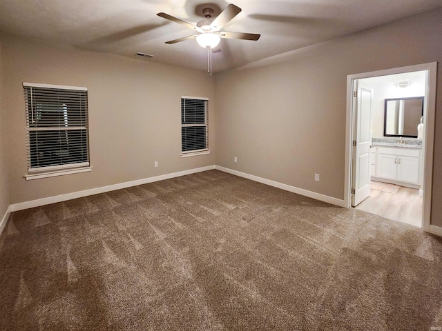 spare room with ceiling fan, sink, and light carpet